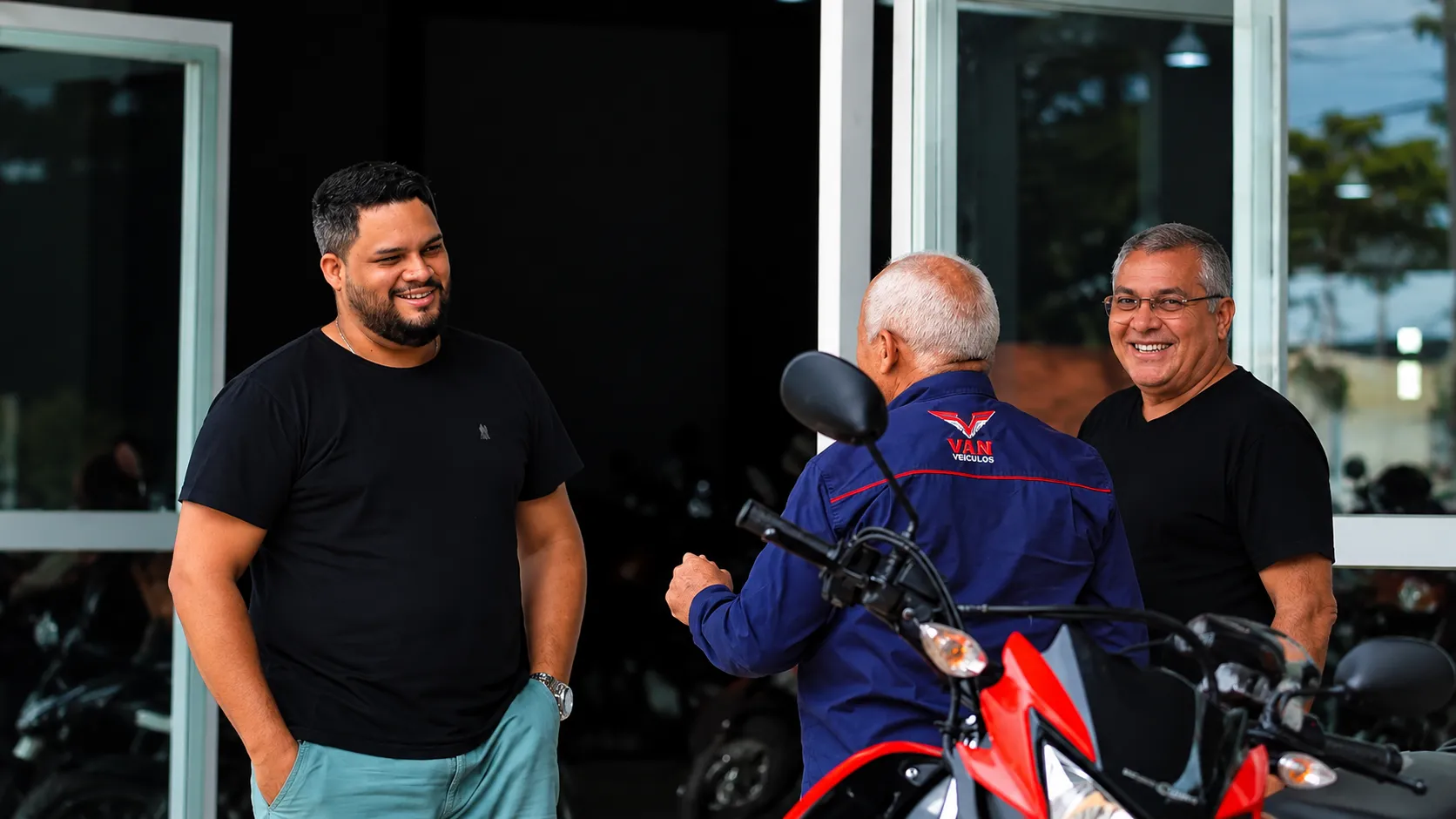 Equipe da Van Veículos conversando com um cliente na entrada da área de motos